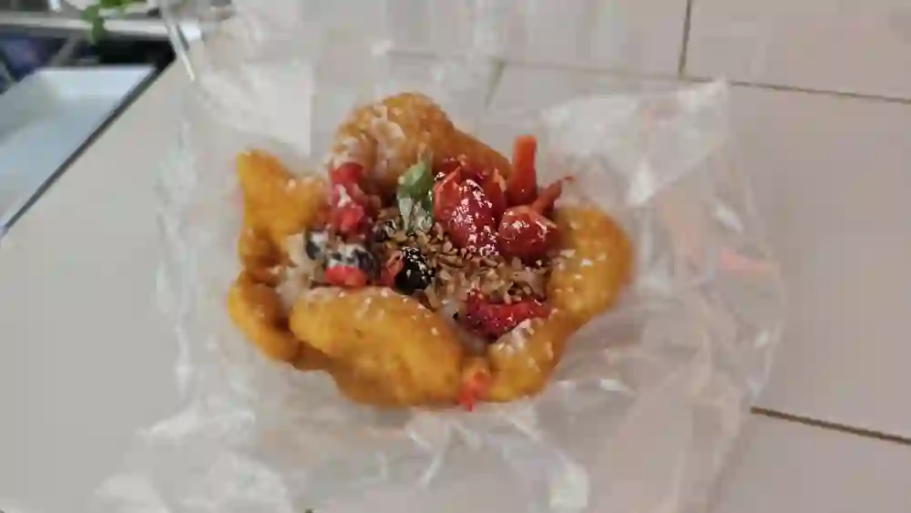 Postre de masa frita con frutos rojos y coco