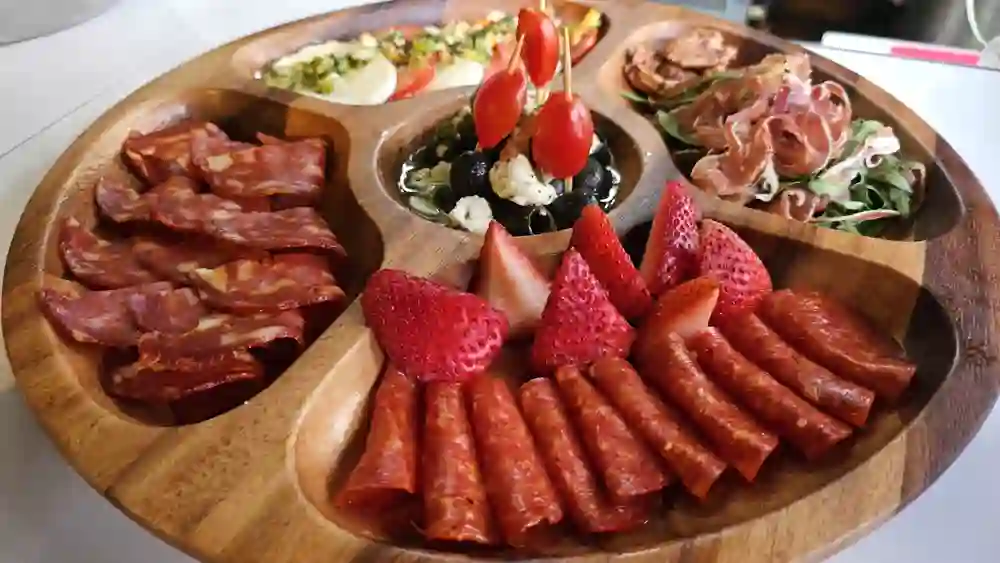 Tabla de embutidos, quesos, aceitunas y fresas